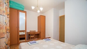 Un dormitorio con cama, escritorio y armario.