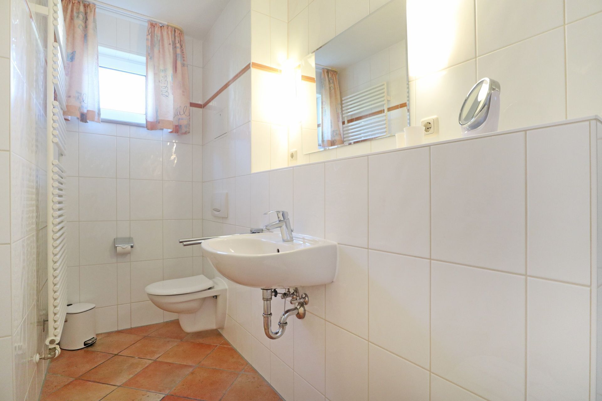 A bathroom with a white sink, toilet, and shower.