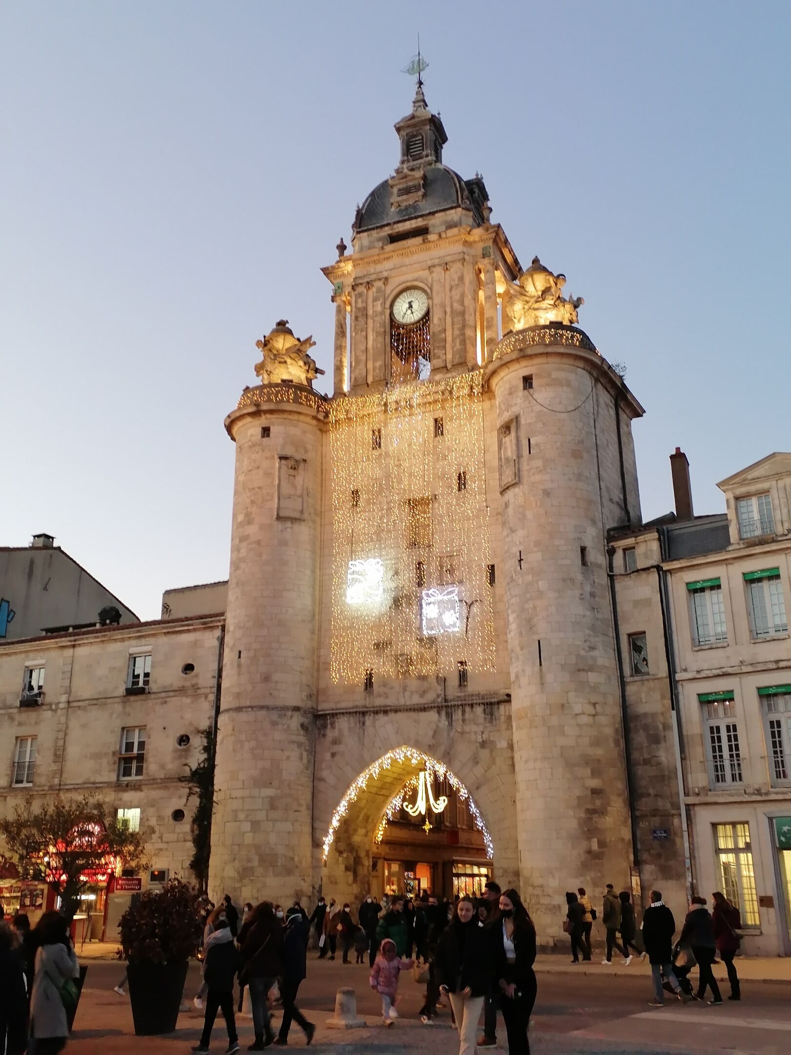 A historic building with a clock tower, ornate decorations, and a large archway.