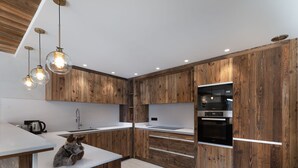 Une cuisine moderne avec des meubles en bois, un plan de travail blanc et un four encastré.