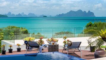 Alberca al aire libre, sombrillas en la alberca y camastros