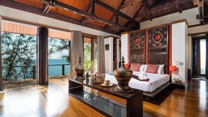 Une chambre spacieuse avec un grand lit, un plafond en bois et une vue sur la mer.
