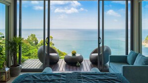 A modern bedroom with a large sliding glass door leading to a balcony overlooking a scenic ocean view. - Villa Samira by Elite Havens (Kamala)