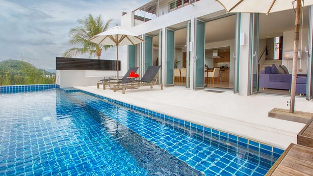 A modern outdoor pool area with a clear blue pool, sun loungers, and a dining area. - Villa Napalai (Choeng Thale)