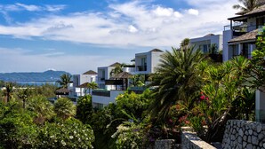 A coastal residential area with modern white buildings, lush greenery, and a clear view of the sea. - Villa Napalai (Choeng Thale)