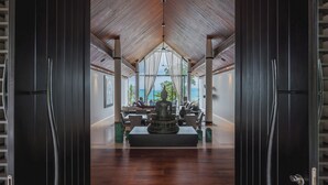 Un interior espacioso con techo alto y vista al océano.
