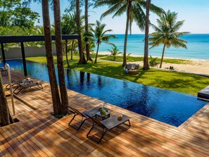 Een buitenzwembad, parasols bij het zwembad en ligstoelen