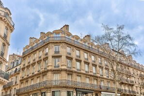 Un edificio de varios pisos con balcones ornamentales y ventanas amplias.