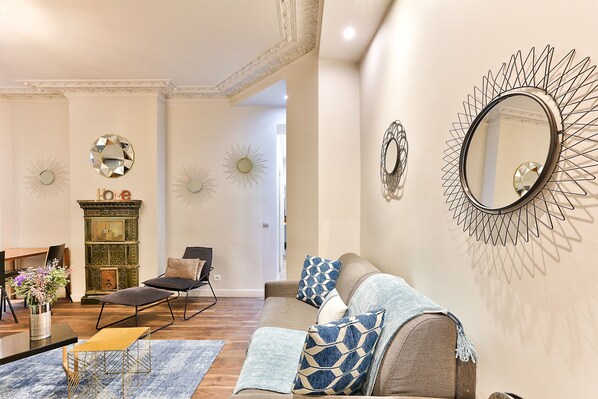 Una sala de estar con sofá, sillones, una mesa de centro y chimenea.
