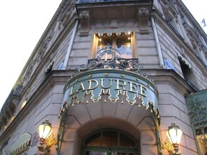 Fachada do edifício Ladurée, com sua entrada ornamentada e sinalização.