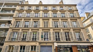 A multi-story building with a classic architectural style, featuring a ground-floor shop named "Le Guynemer." - 75 - Urban Jardins du Luxembourg (París)