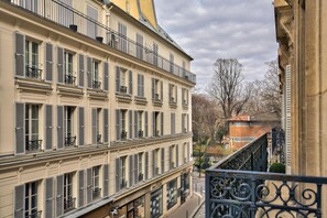 Un immeuble à plusieurs étages doté de balcons, de grandes fenêtres et donnant sur la rue.