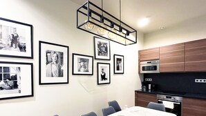 A modern kitchen with wooden cabinets, a built-in oven, and a dining area with a table and chairs.