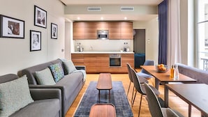 A modern apartment with a living room, dining area, and kitchenette. - UrbanFlat 79 - Beautiful Large Apartment in Paris Le Marais (París)