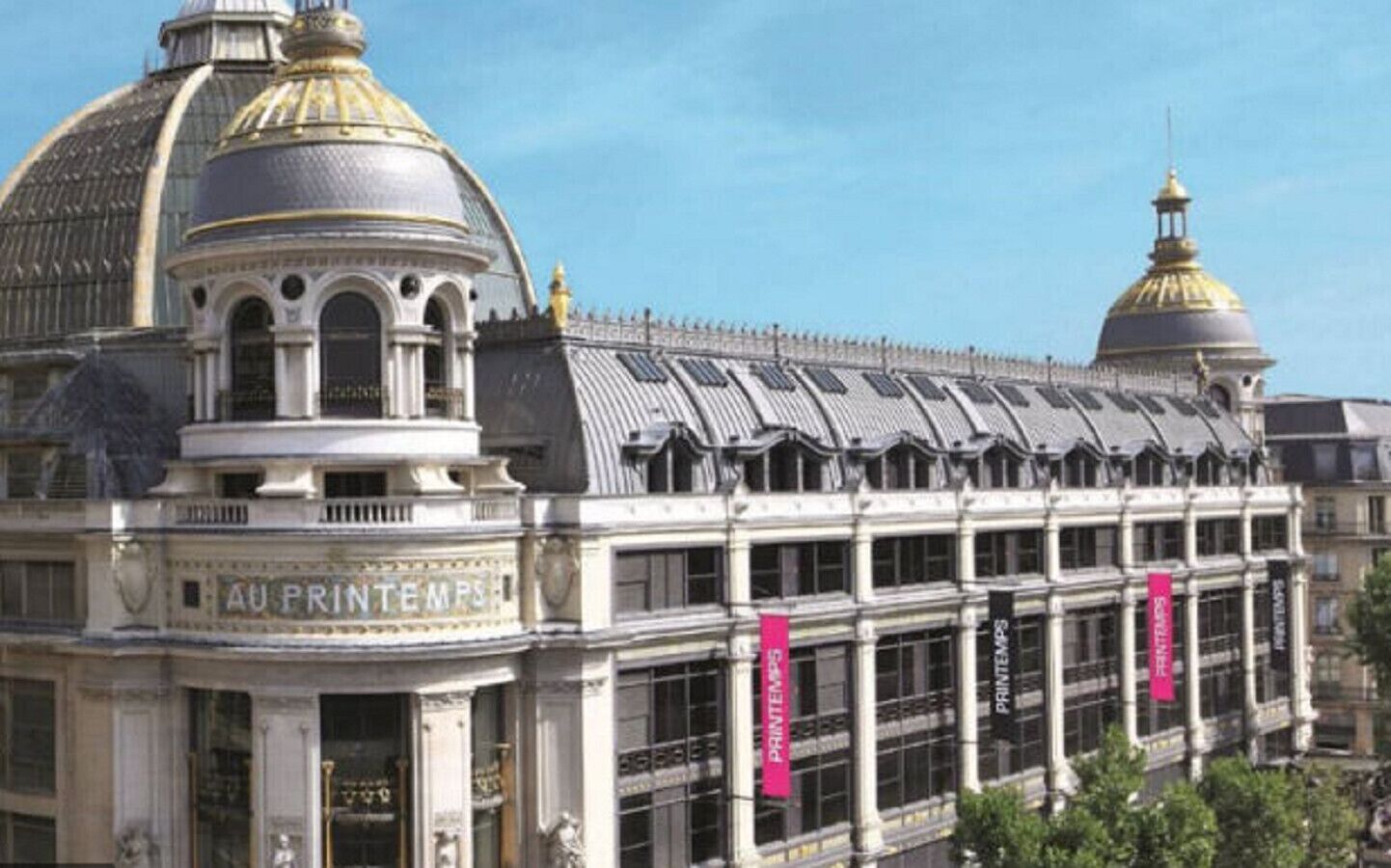 A historic building with a large dome and a sign reading "Au Printemps".