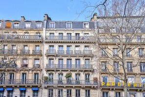 Un edificio de varios pisos con balcones y un letrero que dice 'PAPERERIE'.