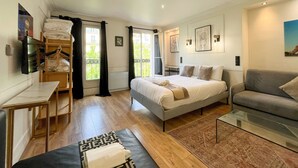 A modern bedroom with a bed, a sofa, a desk, and a window. - 102 - Urban Opera Picasso (París)
