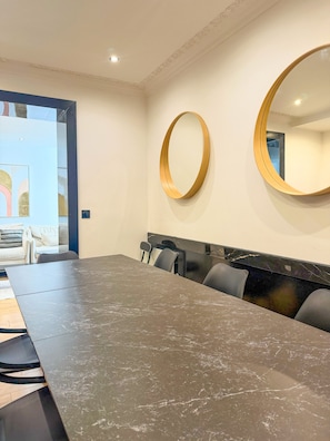 A conference room with a long table, chairs, and two wall-mounted mirrors.