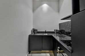 A modern kitchen with a dark countertop, a sink, and a stove.