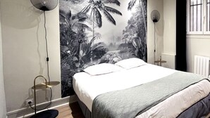 A bedroom with a large bed, two floor lamps, a radiator, and a window with bars. - Urban Flat 06 - Charming 2 BDR in Paris (París)