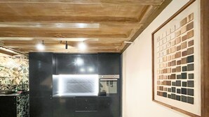 Una cocina con armarios oscuros, una campana extractora de acero inoxidable y un salpicadero de azulejos.