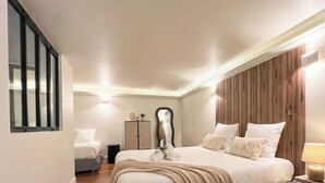 Una habitación de hotel con cama, armario, espejo y ventana.