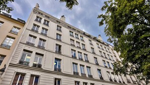 Un edifici de diverses plantes amb balcons, grans finestres i un estil arquitectònic clàssic.