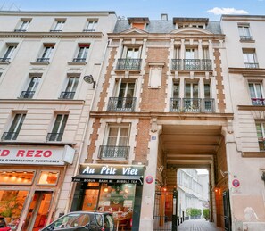 A street view of a building with a cafe named "Au P'tit Vêt" at the ground level. - Urban Flat 33 - Charming Flat near Champs-Elysees (París)