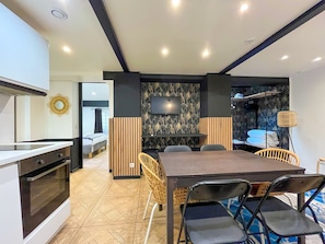 A modern kitchen with a built-in oven and a dining area with a table and chairs. - UrbanFlat 86 - Maison de ville au centre de Paris (París)