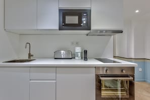 A compact kitchen with a built-in microwave, a coffee maker, and a toaster. - UrbanFlat 86 - Maison de ville au centre de Paris (París)