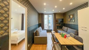 Une chambre moderne comprenant un lit, un canapé, une table à manger avec des chaises et un téléviseur.