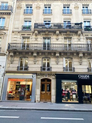 A building with a ground-floor boutique store named 'Charm Collection' and a restaurant with a glass facade. - UrbanFlat 90 - Designer Apartment in Center of Paris (París)