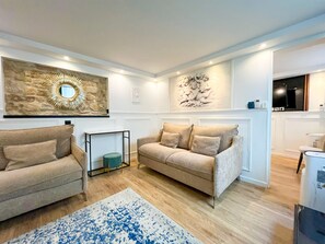 A living room with two sofas, a coffee table, a rug, and wall art.