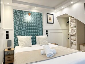 A hotel room with a bed, a nightstand, a lamp, a framed picture, and a built-in closet.
