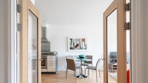 Eine moderne Küche mit Essbereich, Holzboden und einem Gemälde an der Wand.