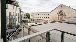 Ein modernes Gebäude mit Innenhof, das Backstein- und Glasfassaden kombiniert, mit einigen Fahrrädern davor.