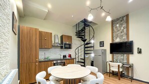 Una cocina moderna con armarios de madera, un microondas integrado y una escalera de caracol.