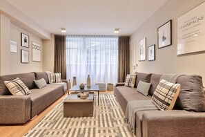 A modern living room with two sofas, a coffee table, and a patterned rug.