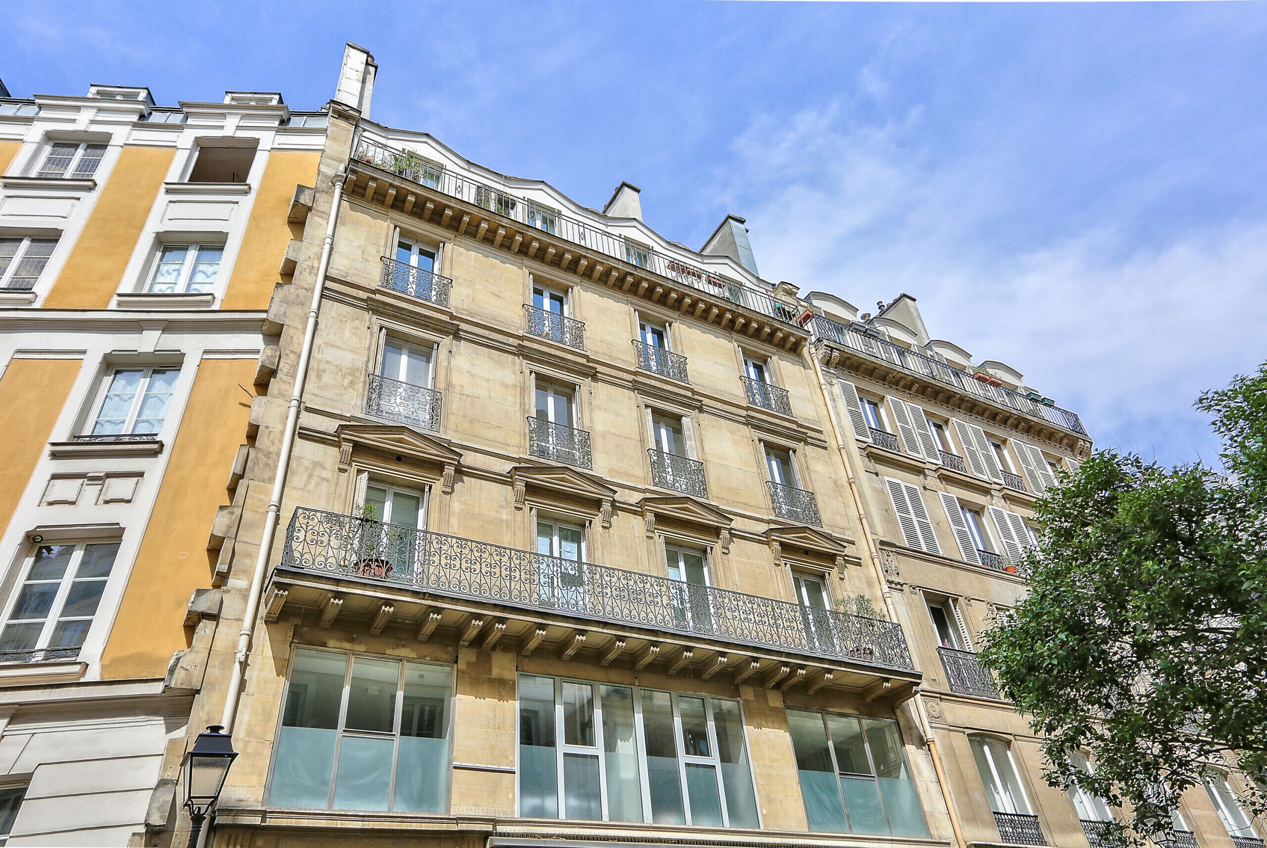 A multi-story building with balconies and large windows.