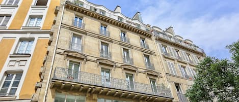 A multi-story building with balconies and large windows.