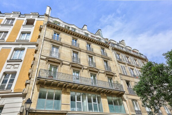 A multi-story building with balconies and large windows.