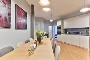 A modern kitchen with white cabinets, a wooden countertop, and a built-in oven.