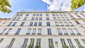 A multi-story building with a symmetrical facade, large windows, and balconies.