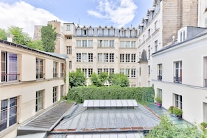 A courtyard with a central building featuring multiple windows and a peaked roof.