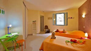 Une chambre avec deux lits, un bureau avec une chaise, une petite table et une fenêtre donnant sur un paysage agréable.