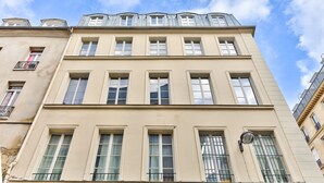 A multi-story building with a classic architectural style, featuring large windows and a flat roof.