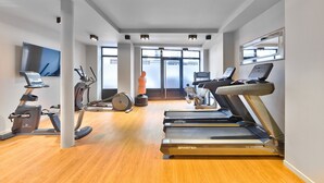 Ein Fitnessstudio mit Laufbändern, Ergometer und Crosstrainern.