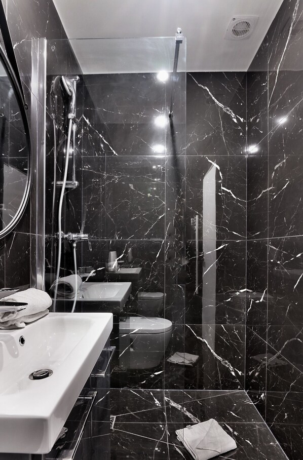 A modern bathroom with a glass shower enclosure, a white sink, and a toilet. - Urban Flat 99 - Spacious 6 BDR Apartment in Paris (París)