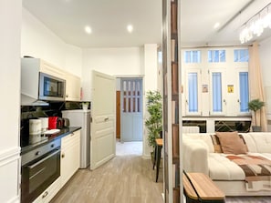 A compact living space with a kitchenette, a dining area, and a bedroom.
