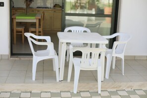 A dining area with a white table and four white chairs. - Cala Verde Residence - Two-room apartment for 4 people (Marina di Mancaversa)